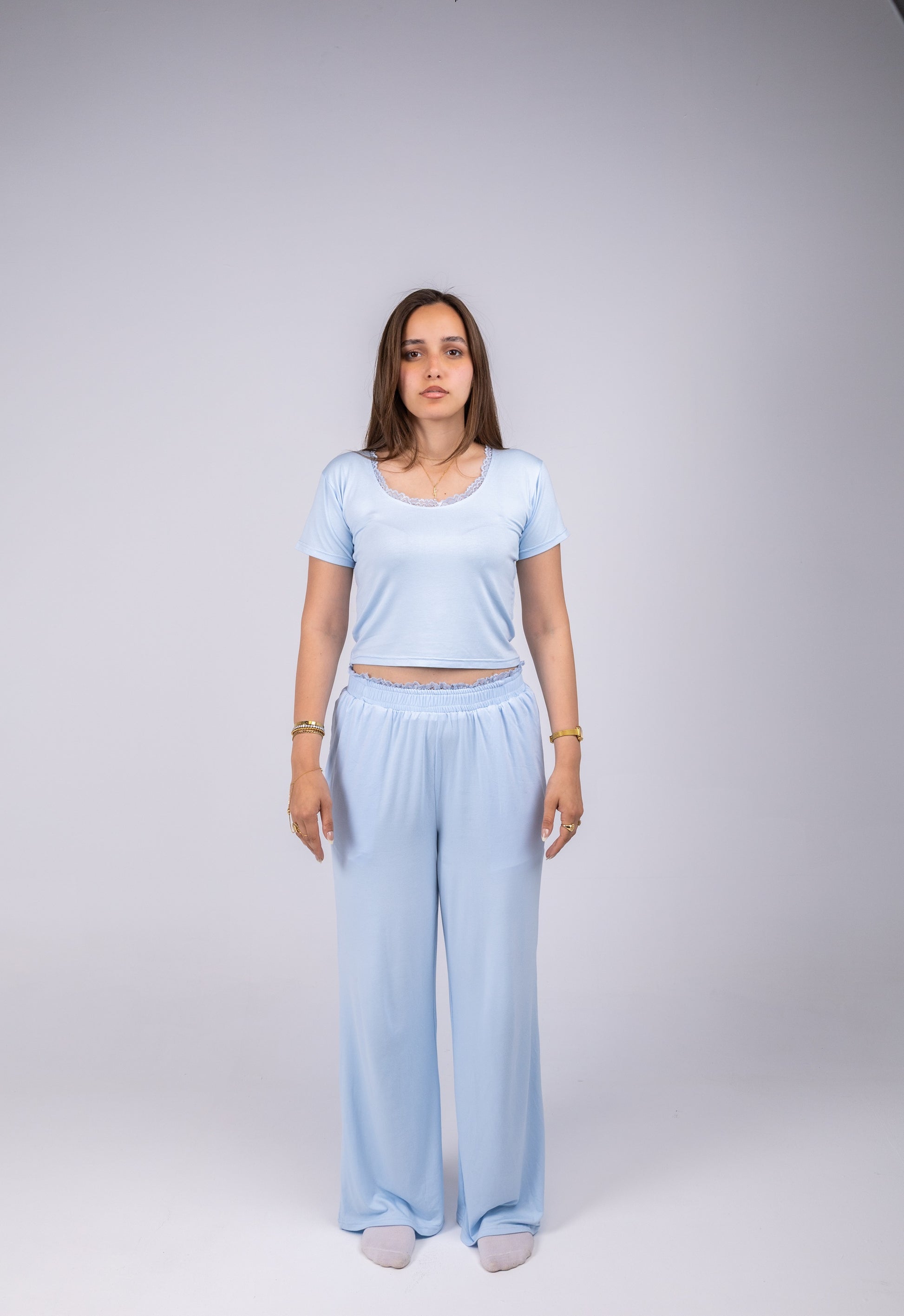 Woman wearing a light blue outfit on a plain background